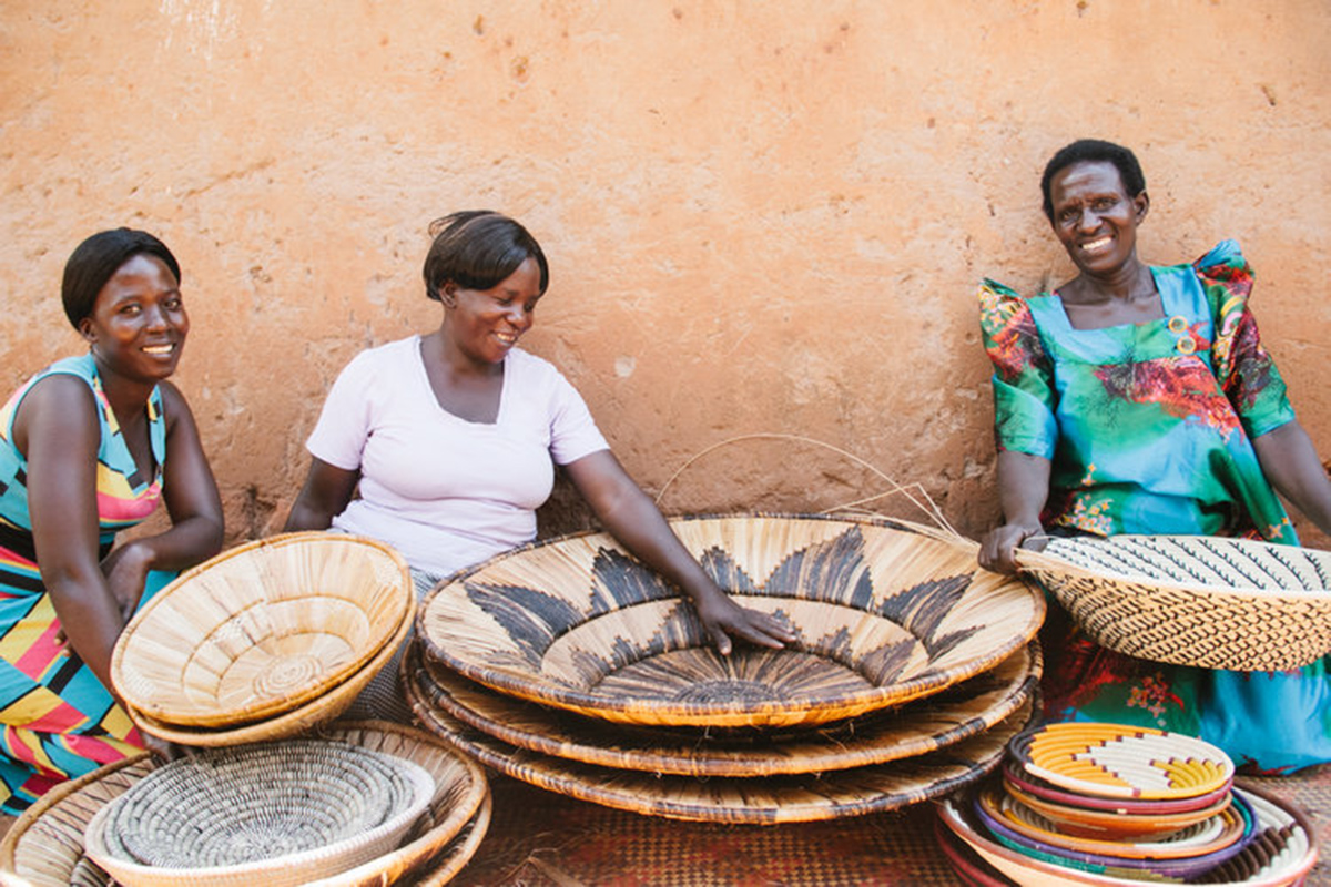 African artisans sit among piles of woven baskets