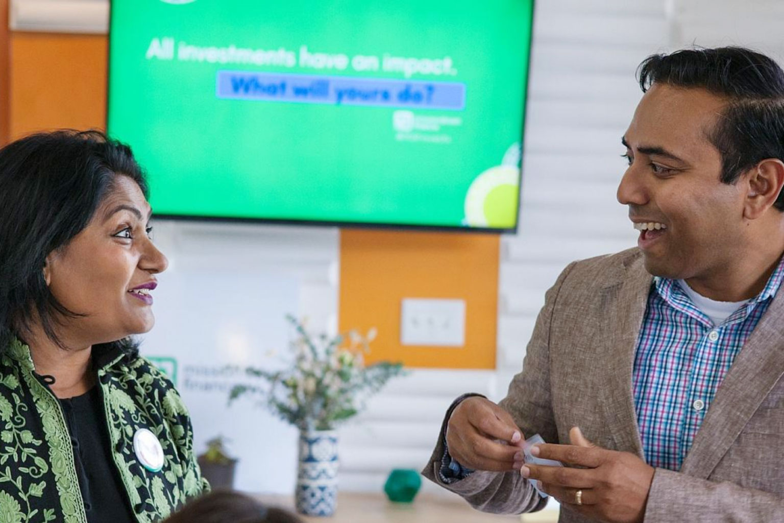 two professionals discuss impact investing at a meeting