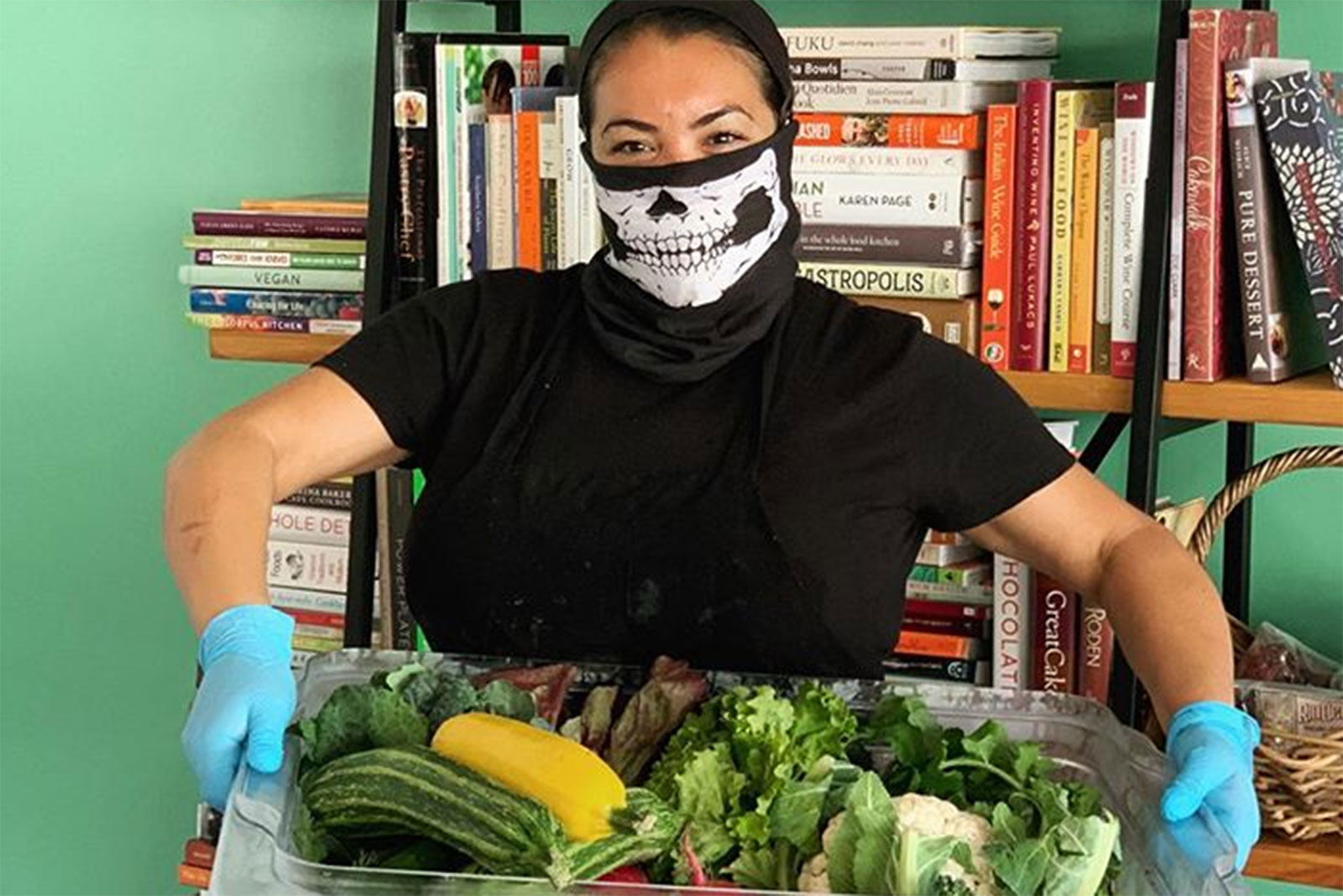 Miranda Gregory, a LuckyBolt employee, holds a bin full of veggies