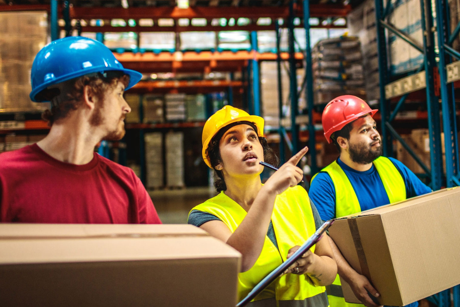 shared ownership warehouse workers wearing hard hats and carrying boxes