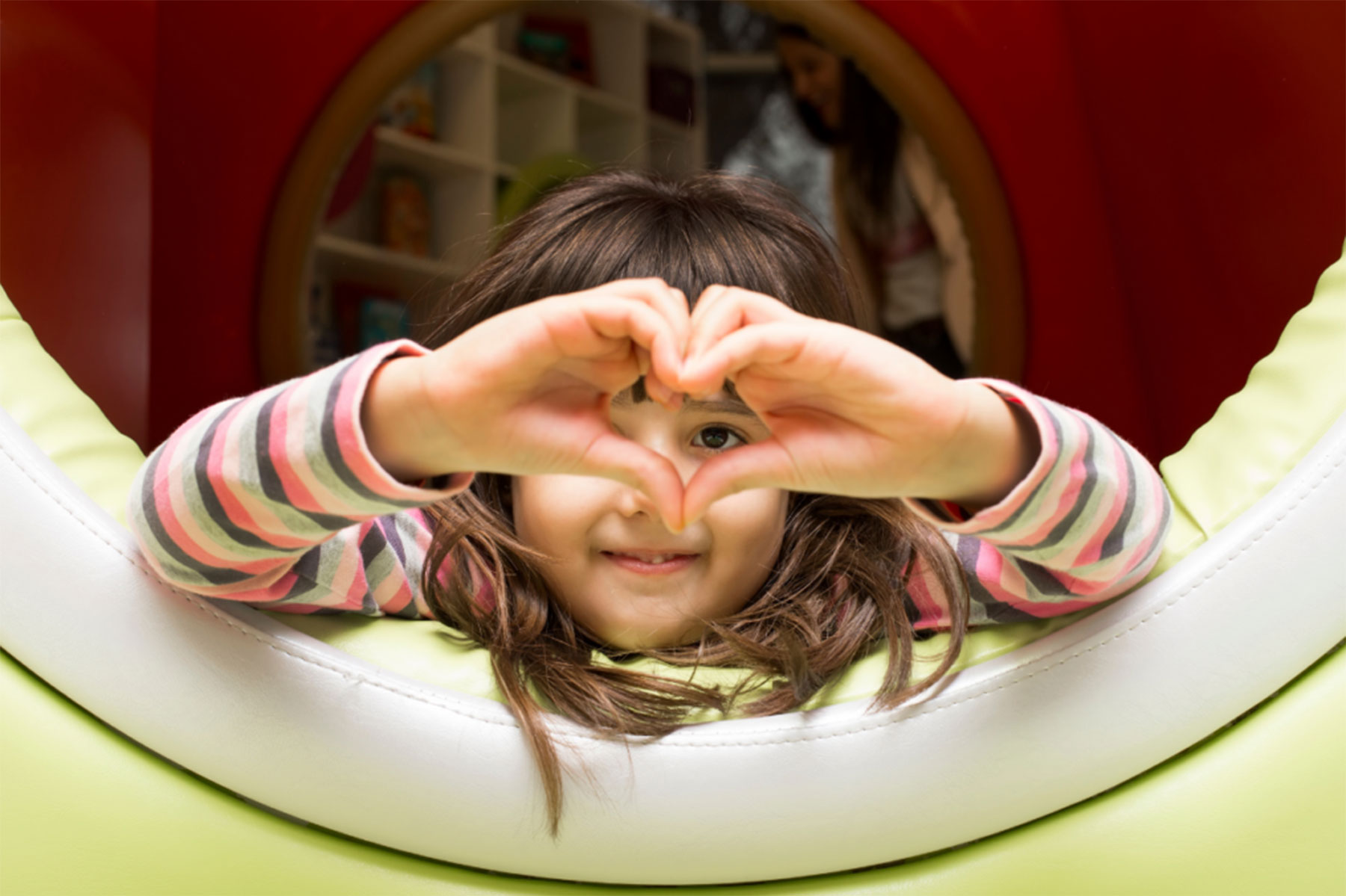 a child makes a heart with her hands