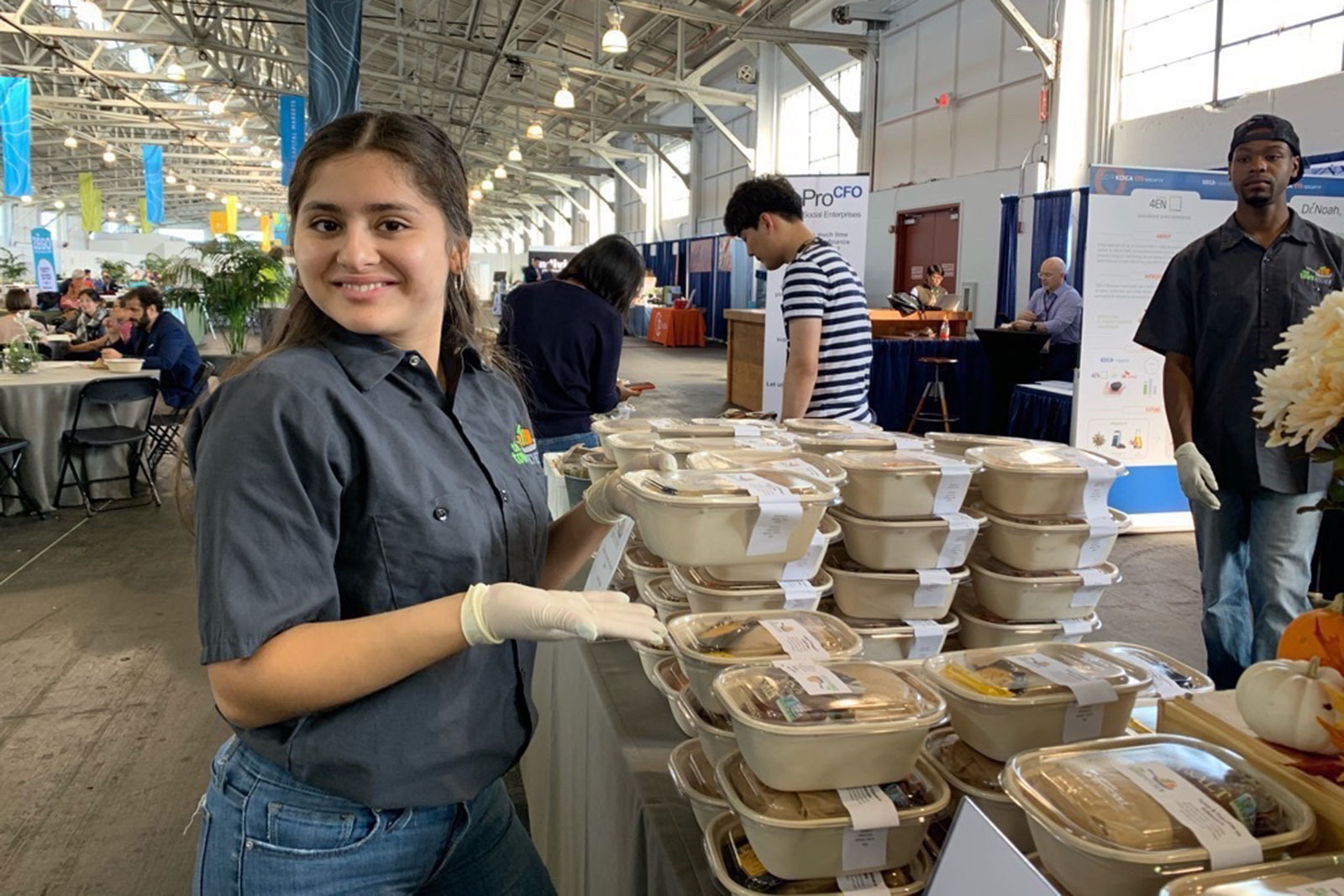TTK-Image-from-iOS-crop A worker from The Town Kitchen stands by a table of catered food at an event
