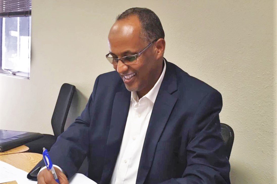 Ahmed Sahid of Somali Family Service of San Diego signing documents at MDF