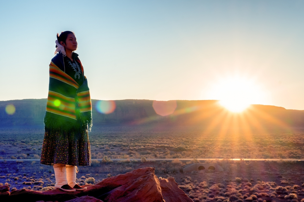 Navajo teenage girl with the sunset behind her