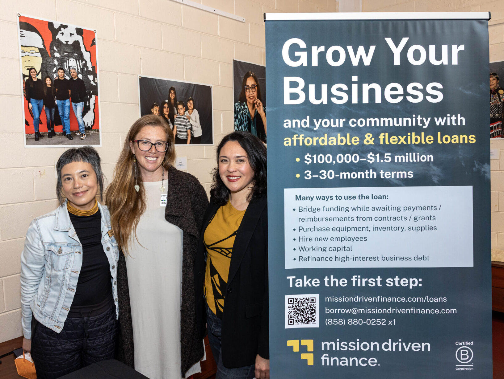 Three women stand next to a banner that says "Grow Your Business"