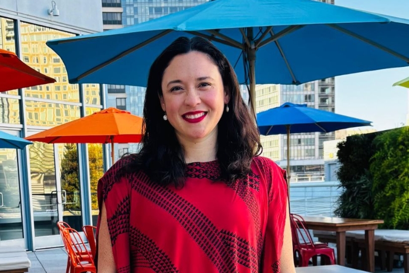 A woman dressed in red smiles for the camera